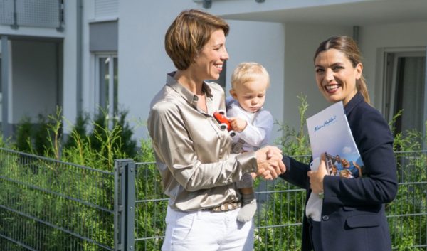 Mutter mit Kind im Beratungsgespräch mit Makler
