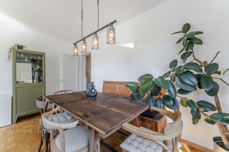 Ein Platz zum Abschalten: Die große Fensterfront bringt Licht, Luft und Leben ins Wohnzimmer – ergänzt durch dekorative Grünpflanzen und Zugang zum Balkon - Licht, Luft & Lebensfreude – 2 Zimmer zum Verlieben in Berg am Laim