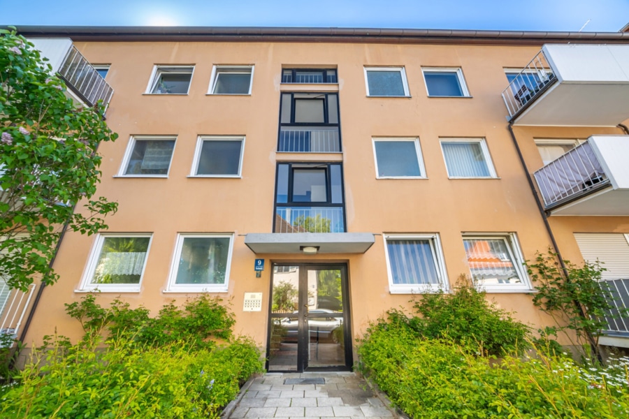 Eingangsbereich zur Wohnanlage Einladend und gepflegt präsentiert sich der Hauseingang der Pachemstraße 9 – umgeben von liebevoll angelegten Grünflächen und einem klar strukturierten Zugang - Licht, Luft & Lebensfreude – 2 Zimmer zum Verlieben in Berg am Laim