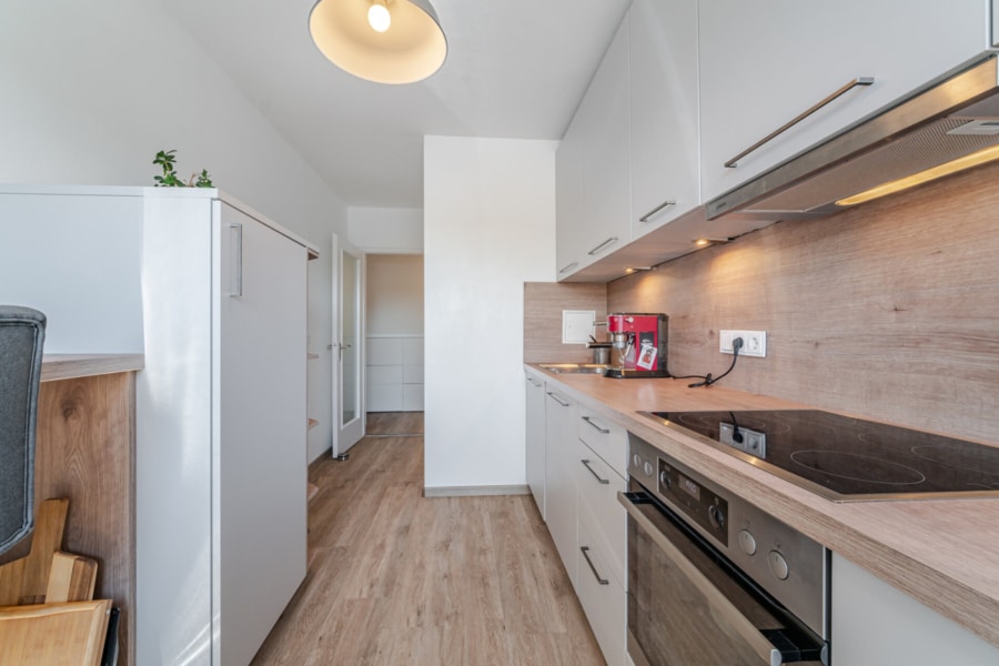 Küche:  Stilvoll & funktional: Die gepflegte Einbauküche mit Kochfeld, Backofen, Spülmaschine und Platz zum Verweilen. Und ja – der erste Kaffee schmeckt hier besonders gut! - Licht, Luft & Lebensfreude – 2 Zimmer zum Verlieben in Berg am Laim