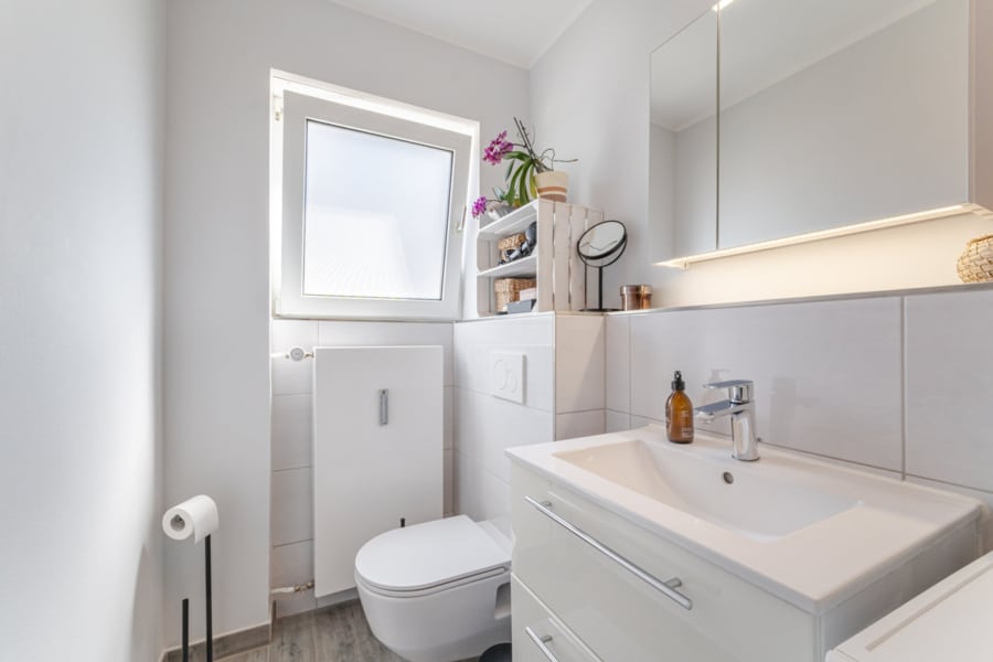 Bad – Waschplatz: Cleane Eleganz: Der helle Waschtisch mit viel Stauraum, großem Spiegel und angenehmer Beleuchtung - Licht, Luft & Lebensfreude – 2 Zimmer zum Verlieben in Berg am Laim