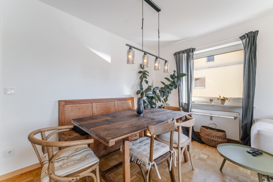 Wohn-Essbereich mit Blick zum Balkon Moderne Gemütlichkeit: Der helle Raum kombiniert stilvollen Essbereich mit bequemer Couchlandschaft – ergänzt durch viel Tageslicht und den Blick ins Grüne - Licht, Luft & Lebensfreude – 2 Zimmer zum Verlieben in Berg am Laim