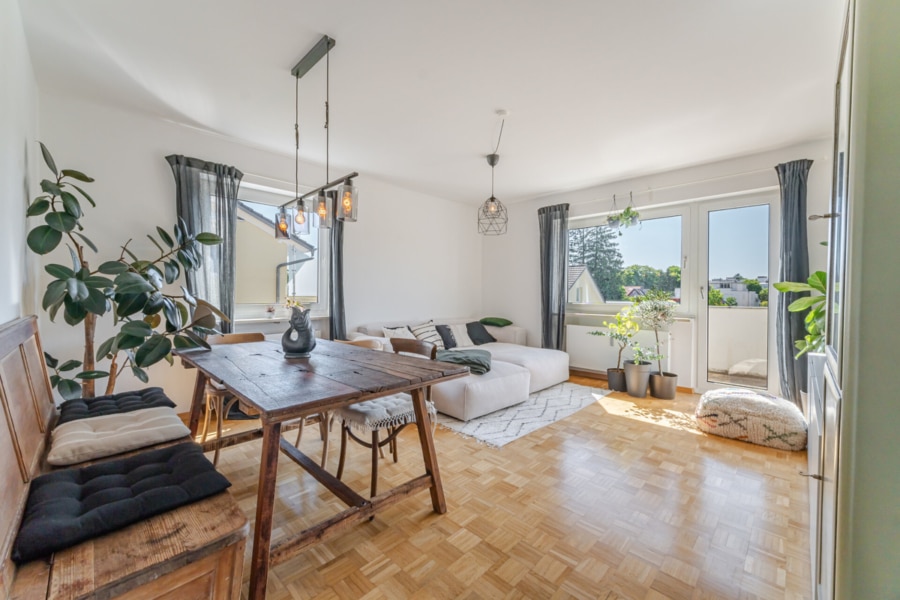 Wohnzimmer mit Essbereich und Balkonzugang Das Herzstück der Wohnung: das lichtdurchflutete Wohnzimmer mit gemütlicher Sitzecke, Essplatz und Westbalkon. Hier lässt sich das Leben genießen - Licht, Luft & Lebensfreude – 2 Zimmer zum Verlieben in Berg am Laim