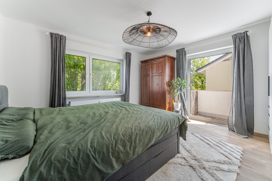 Schlafzimmer mit zwei Fenstern & Zugang zum kleinen Balkon:  Ruhige Nächte garantiert: Das Schlafzimmer mit zwei Fenstern und Zugang zum zweiten Balkon – natürlich auch mit Blick ins Grüne. - Licht, Luft & Lebensfreude – 2 Zimmer zum Verlieben in Berg am Laim