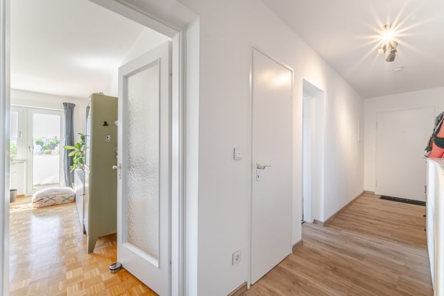 Blick vom Flur ins Wohnzimmer Einladend und lichtdurchflutet – hier öffnet sich der Flur zum großzügigen Wohn-Essbereich mit Zugang zum Balkon - Licht, Luft & Lebensfreude – 2 Zimmer zum Verlieben in Berg am Laim
